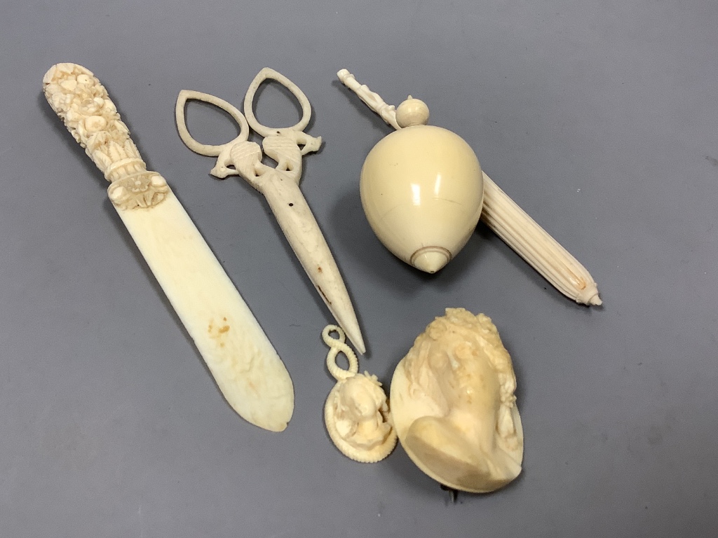 A group of early 19th/20th century ivory including a spinning top and a parasol needle case